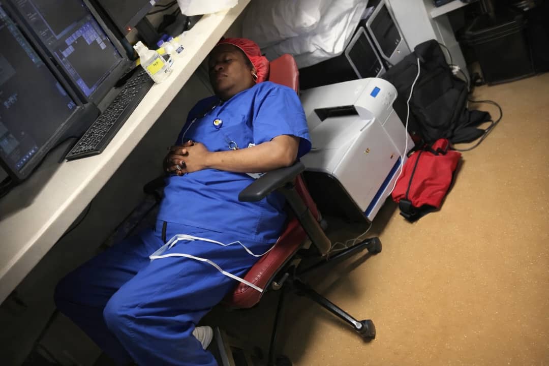 Exhausted healthcare worker asleep during shift showing signs of physician burnout symptoms