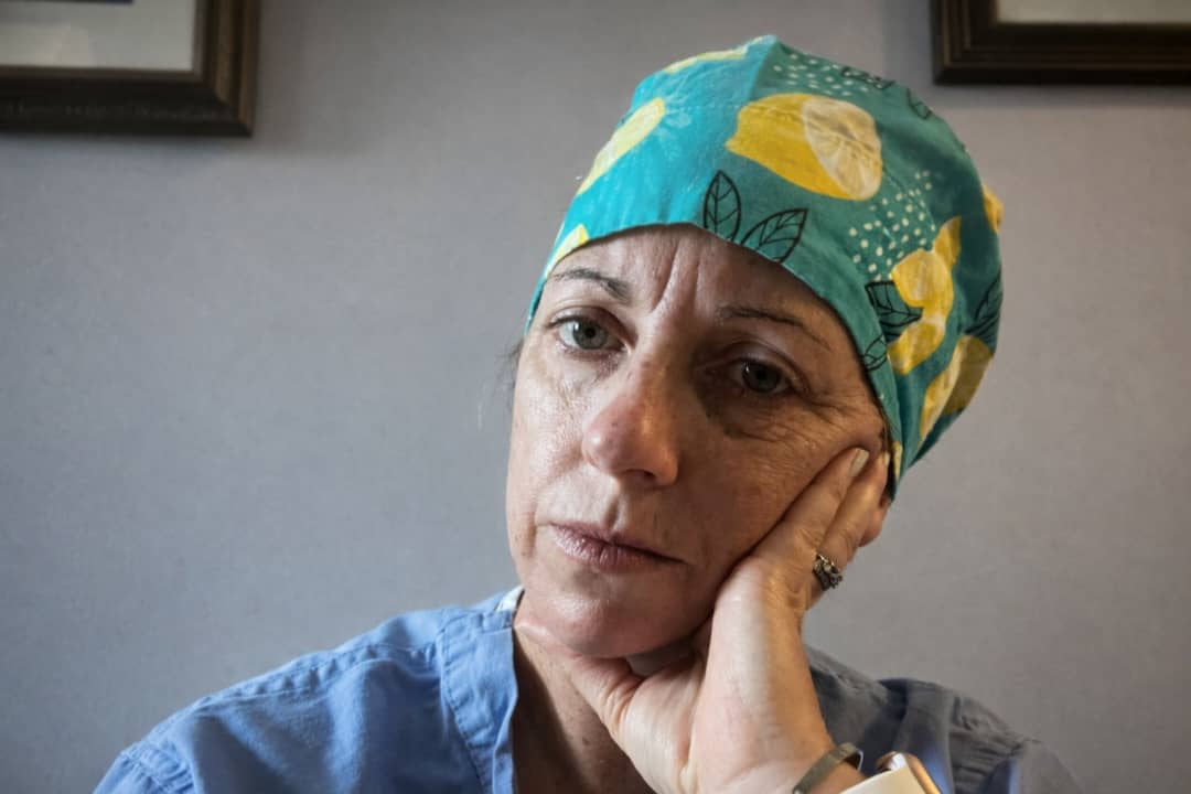 Female healthcare professional looking exhausted and emotionally drained, representing doctors feeling stuck in medicine and career dissatisfaction