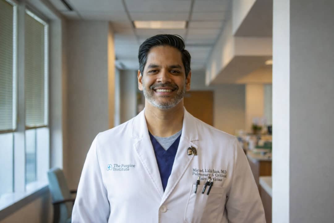 Doctor smiling in hospital hallway despite feeling stuck in medicine and career dissatisfaction